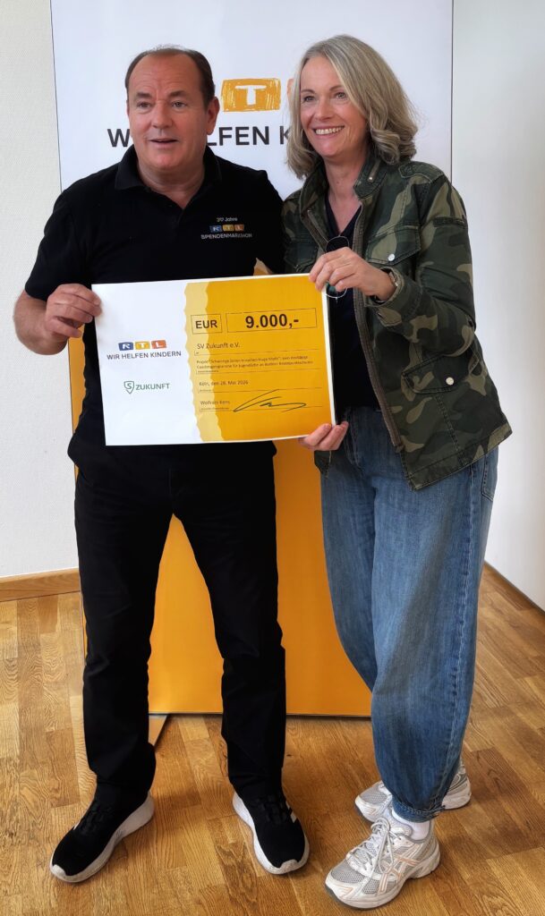 Die Gründerin von SV ZUKUNFT, Birgit Mooser-Niefanger, erhält von Wolfram Kons einen Scheck der RTL-Stiftung. 
